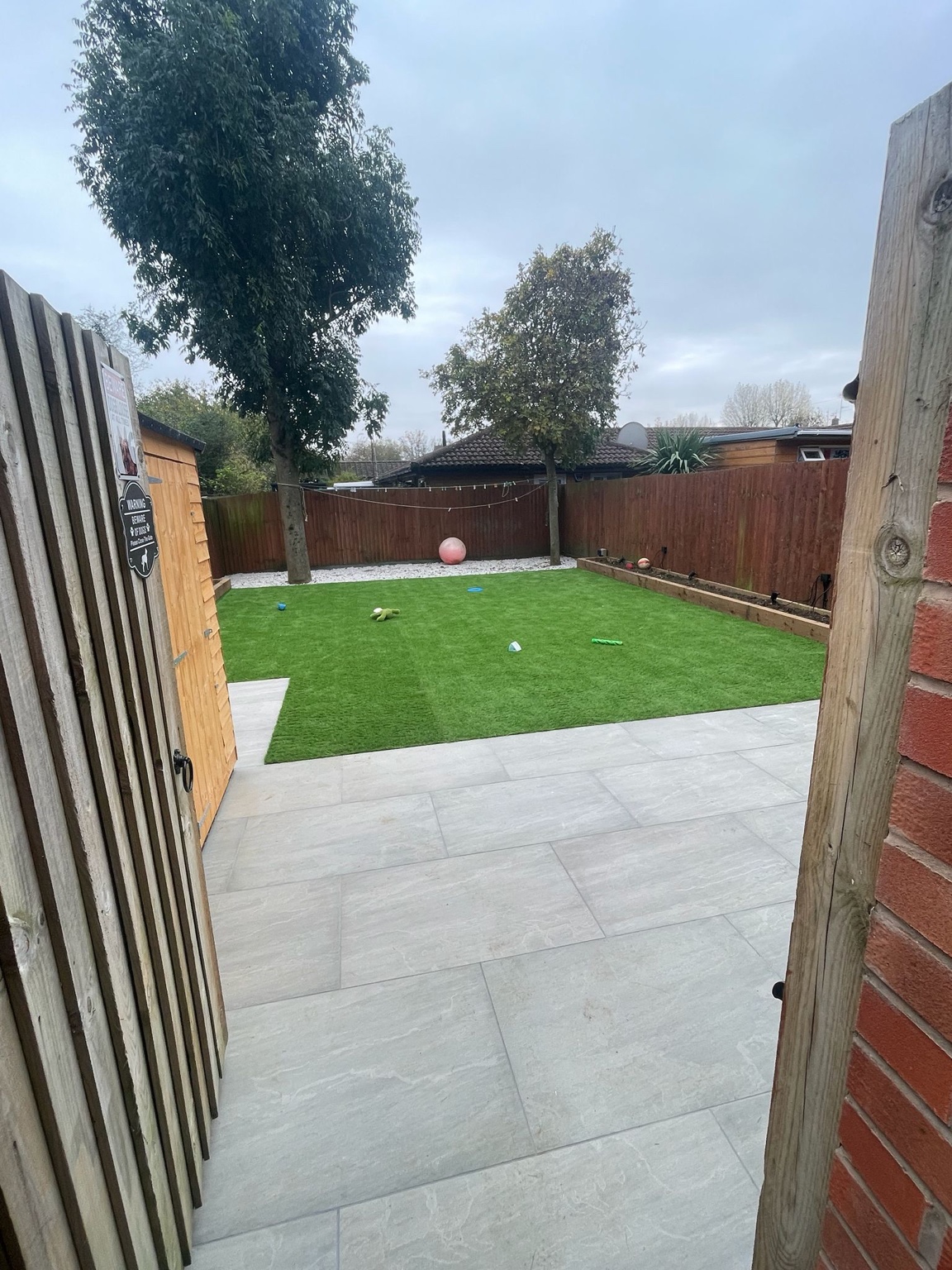 View from the garden gate across the paved patio and green lawn