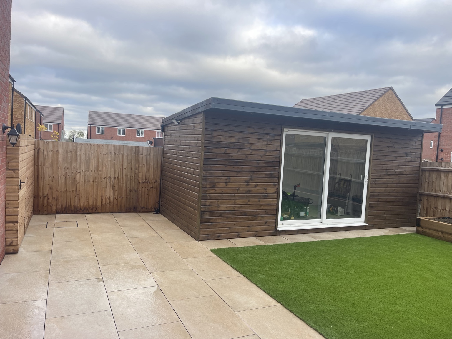 Paving, garden room and artificial grass from the patio