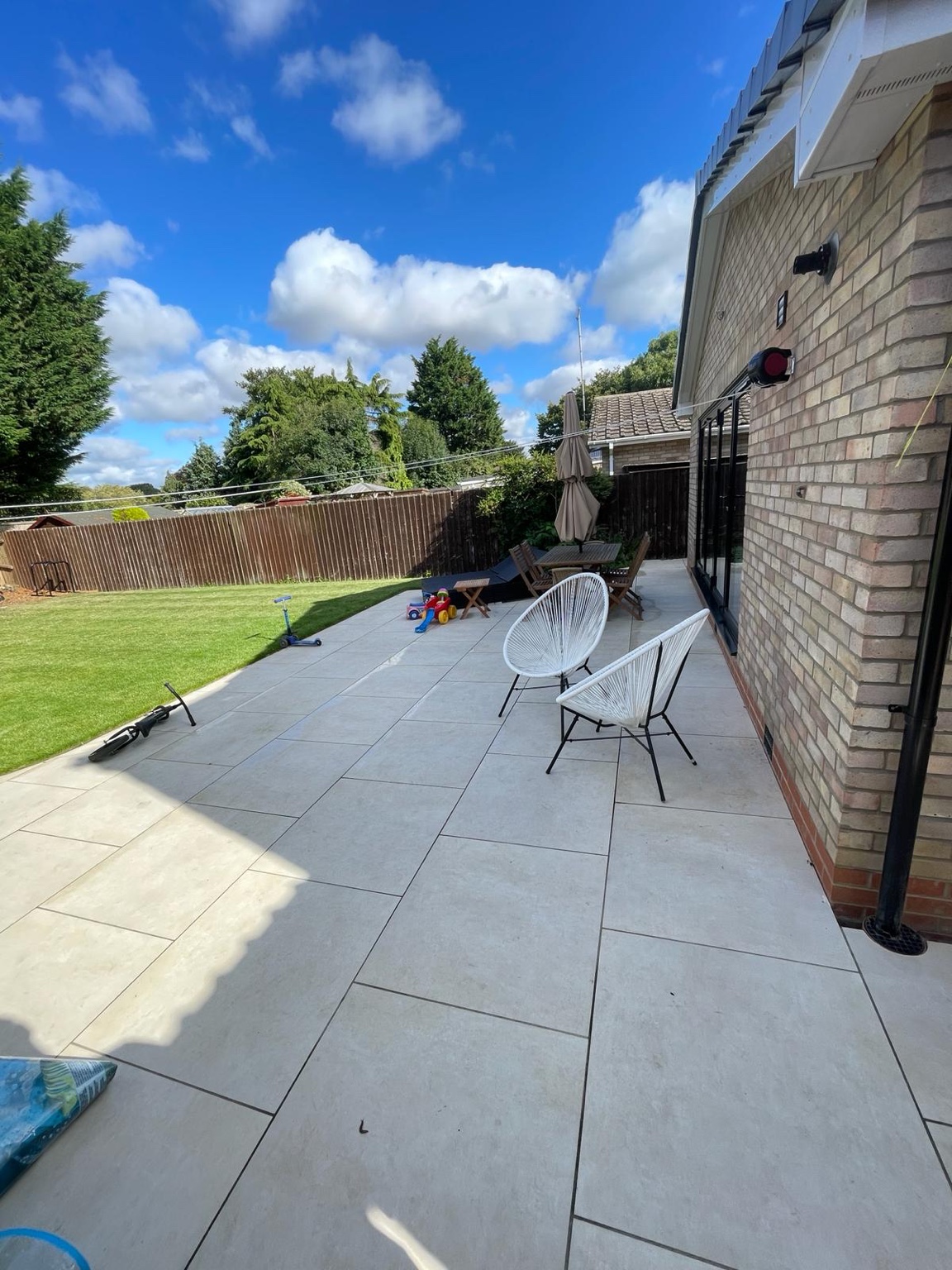 Pale patio paving alongside a garden lawn