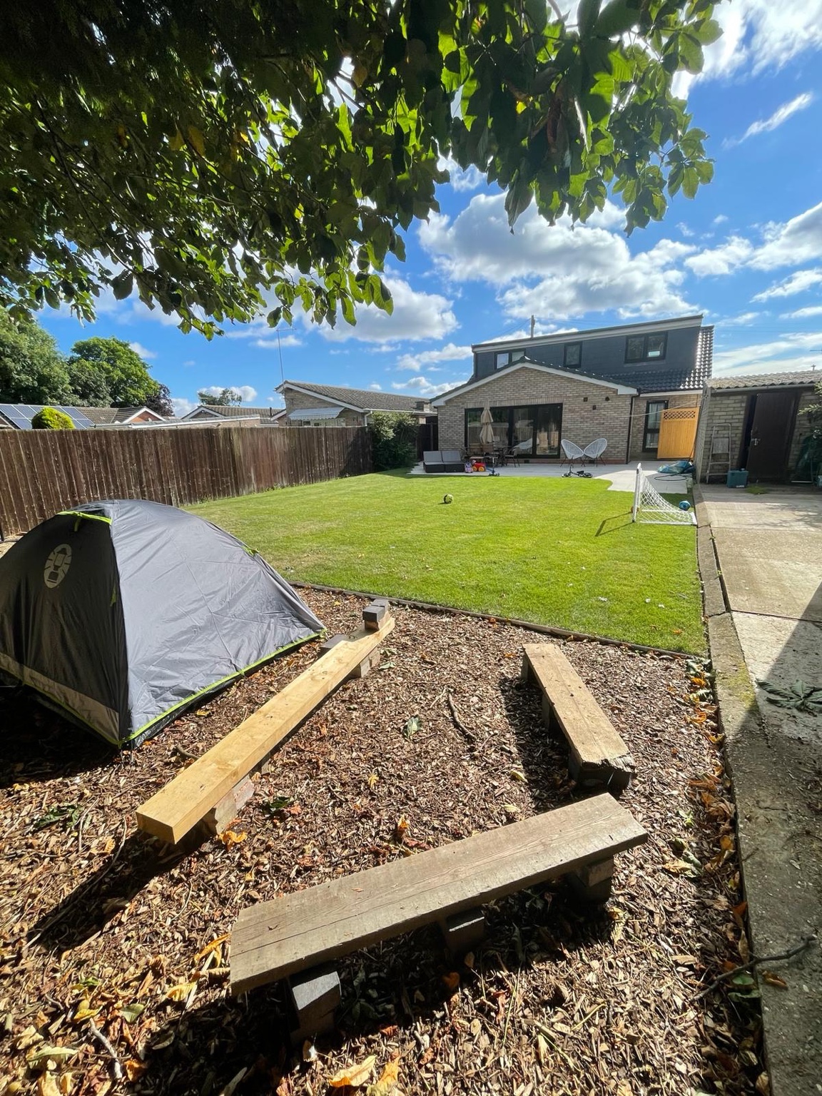 Garden after landscaping with green lawn and timber seating